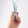 Hand holding a tube of Pharmacian NMN30000 cream