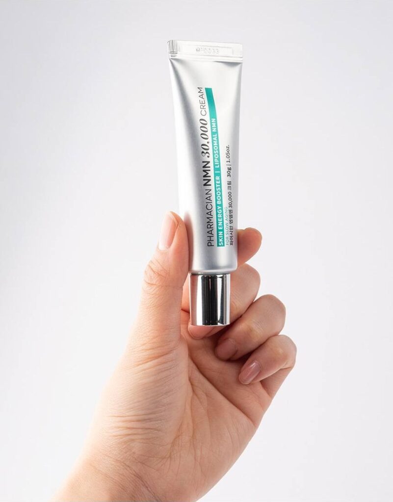 Hand holding a tube of Pharmacian NMN30000 cream