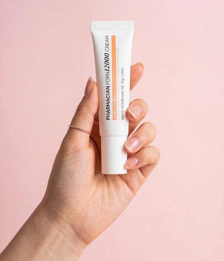 Hand holding a tube of Pharmacian PDRN12000 cream